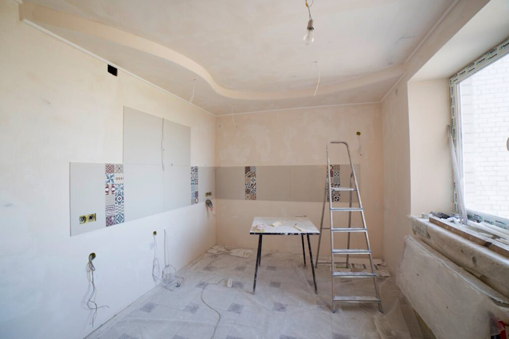 pexels-photo-36035073 Spacious kitchen under renovation with ladder and tools, showcasing a fresh new design.